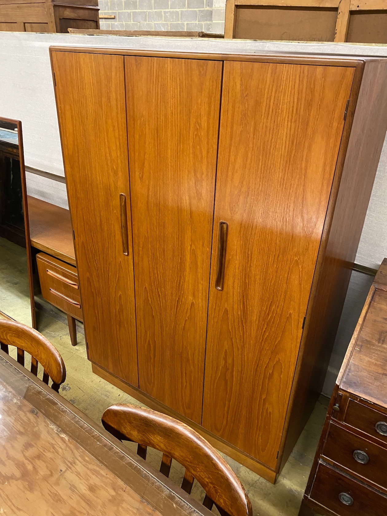 A G-plan teak three piece bedroom suite, comprising wardrobe, width 121cm, depth 58cm, height 176cm, chest of drawers and dressing table